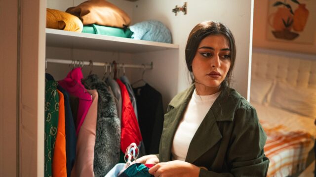 クローゼットの服を前に迷う人