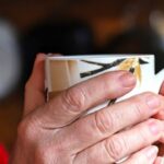 両手で大切そうにマグカップを持つ人